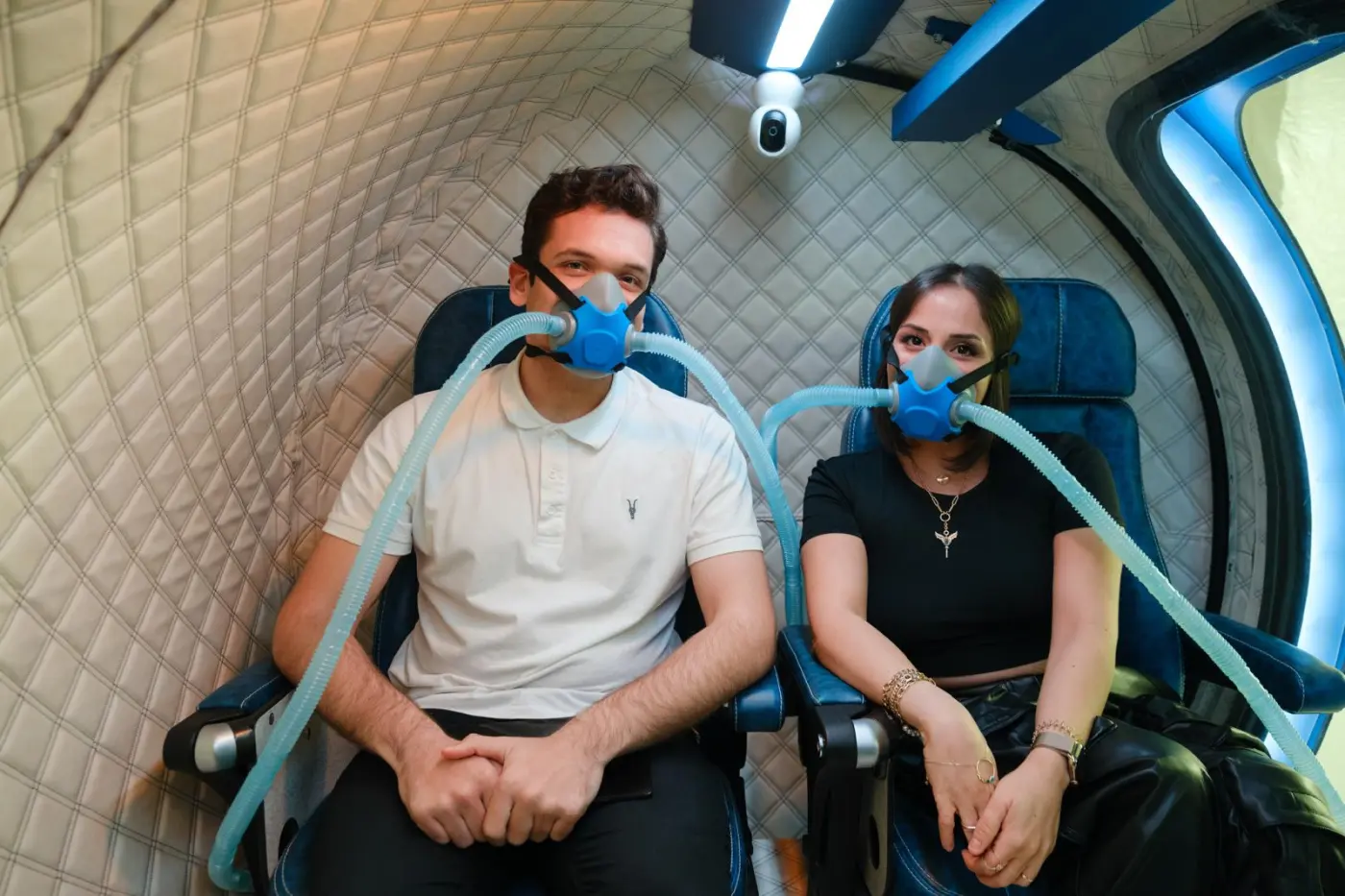 Dvojice klientů během sezení v hyperbarické komoře s kyslíkovými maskami